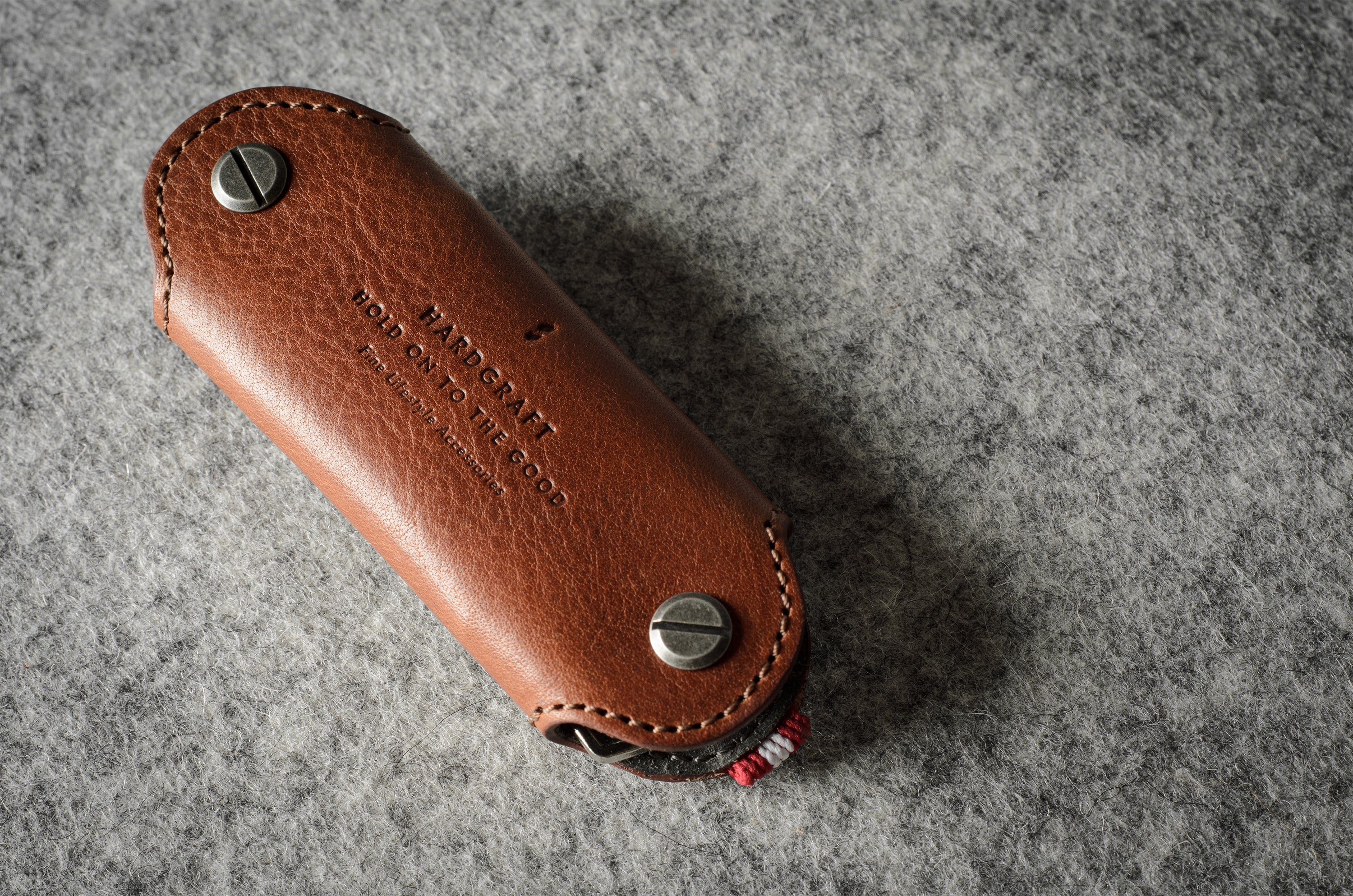 Multi-key pouch made of brown leather on a gray background